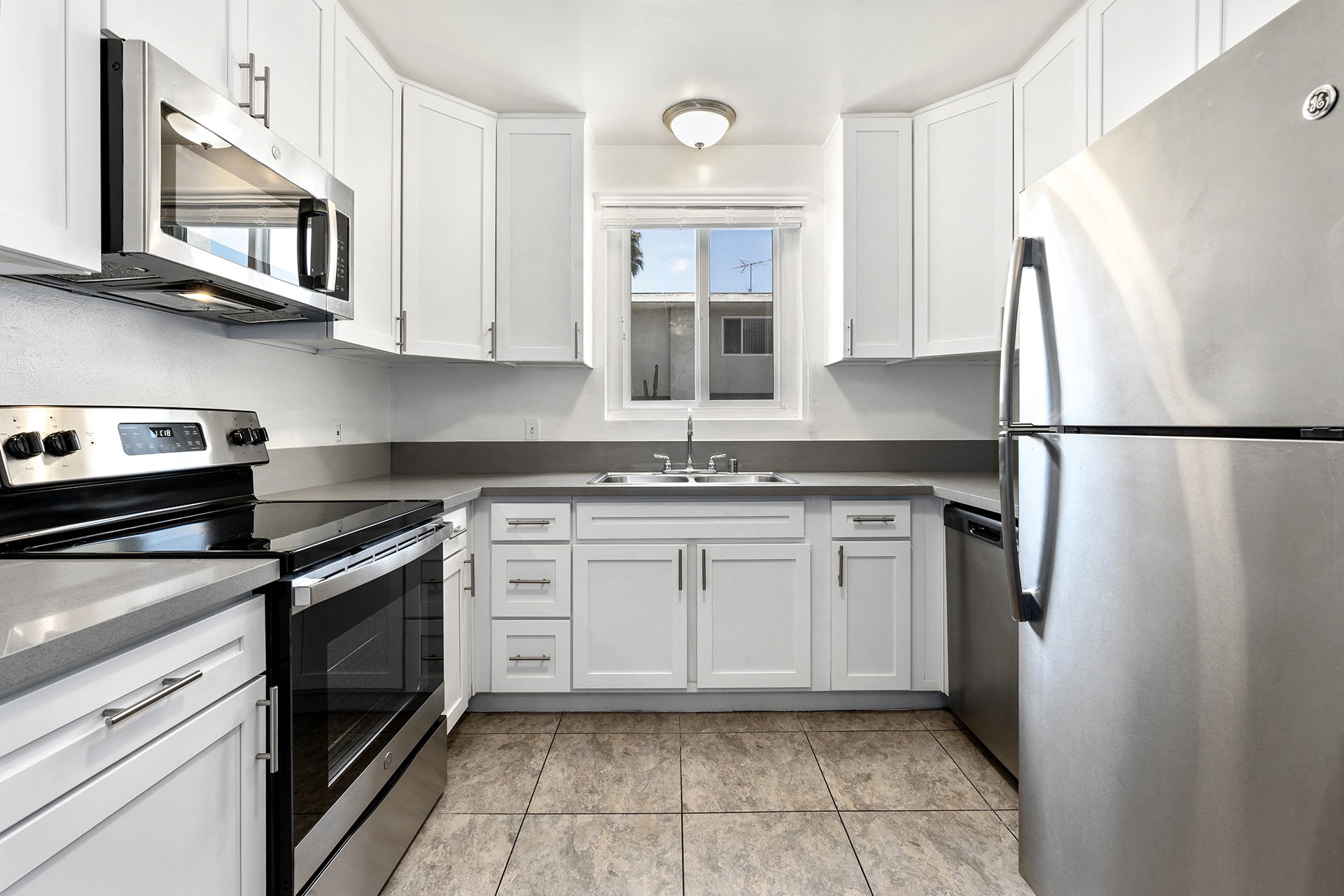 a kitchen with white cabinets and black appliances